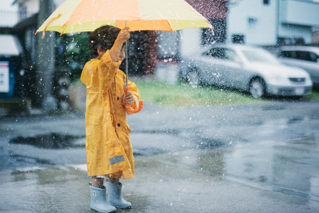 大雨の中おでかけをする子供